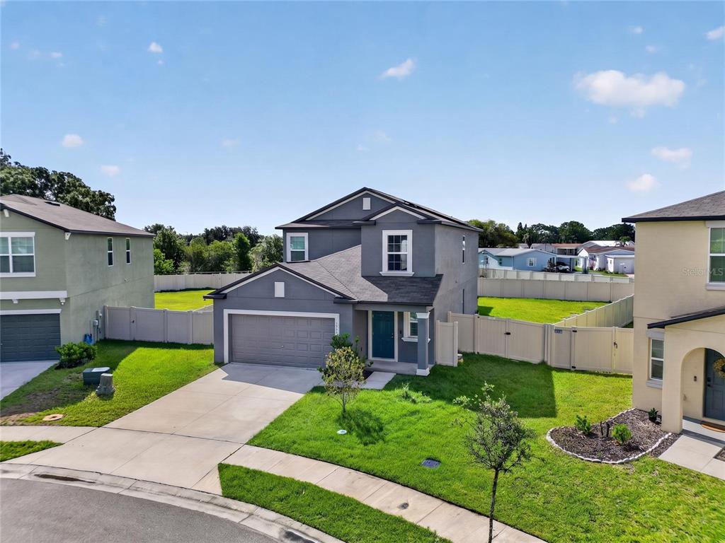 A two-story suburban house with a gray exterior, a two-car garage, and a fenced yard — 1779 YELLOW TRAIL, LAKELAND, FL