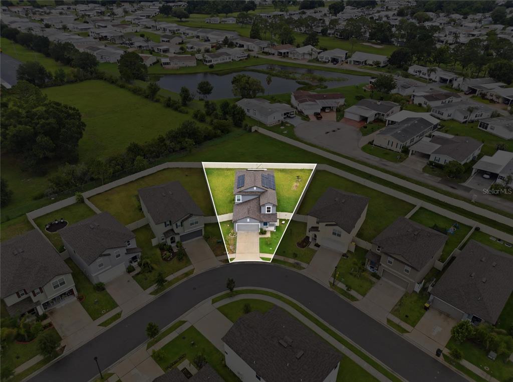 An aerial view shows a single-family home with solar panels on a cul-de-sac lot — 1779 YELLOW TRAIL, LAKELAND, FL