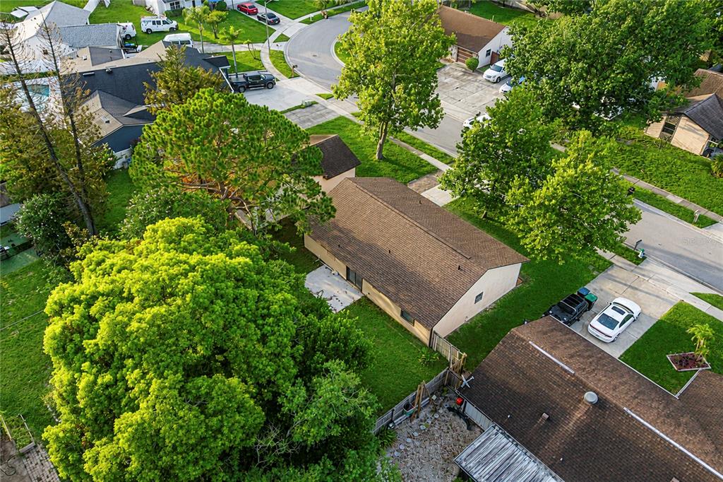 An aerial view shows a residential house with a brown roof surrounded by green trees — 7621 RUTHWIND COURT, ORLANDO, FL