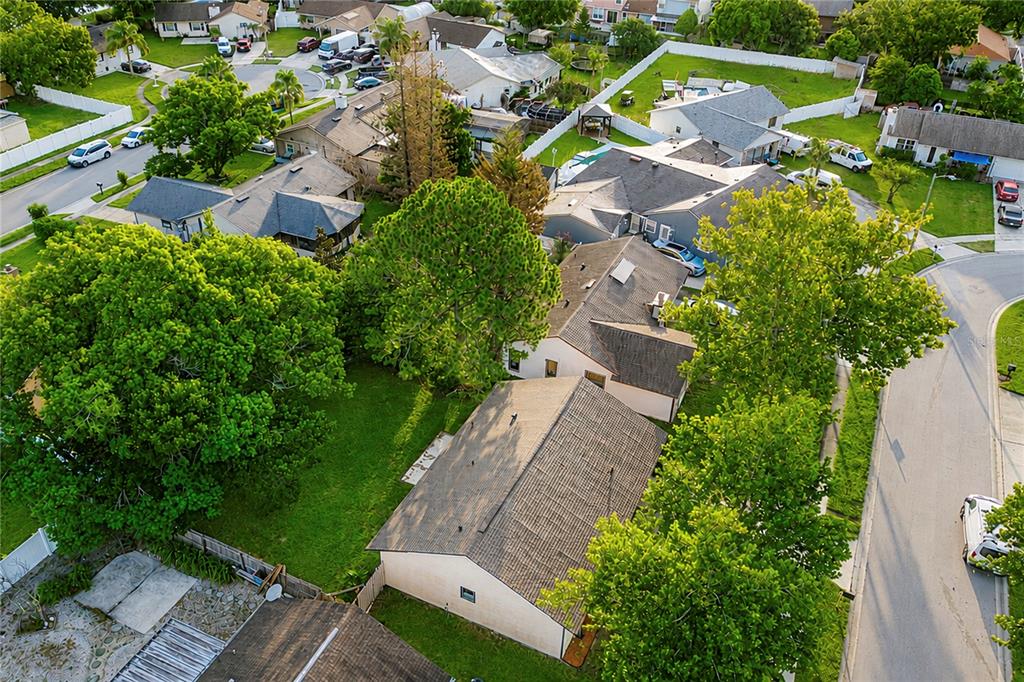 An aerial view shows several suburban houses with shingled roofs surrounded by trees and lawns — 7621 RUTHWIND COURT, ORLANDO, FL