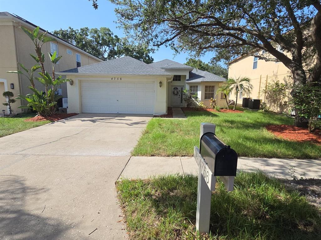 A screened-in pool and spa area with a patio and surrounding green landscape — 4756 WHISPERING WIND AVENUE, TAMPA, FL
