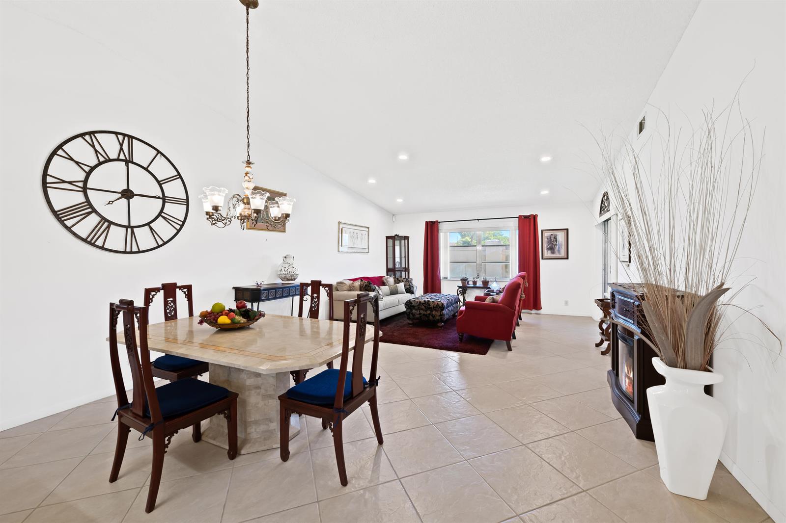 A dining area with a stone table and chairs opens into a living room with red curtains — 8236 Summerbreeze Lane, Boca Raton FL 33496, BOCA RATON, FL