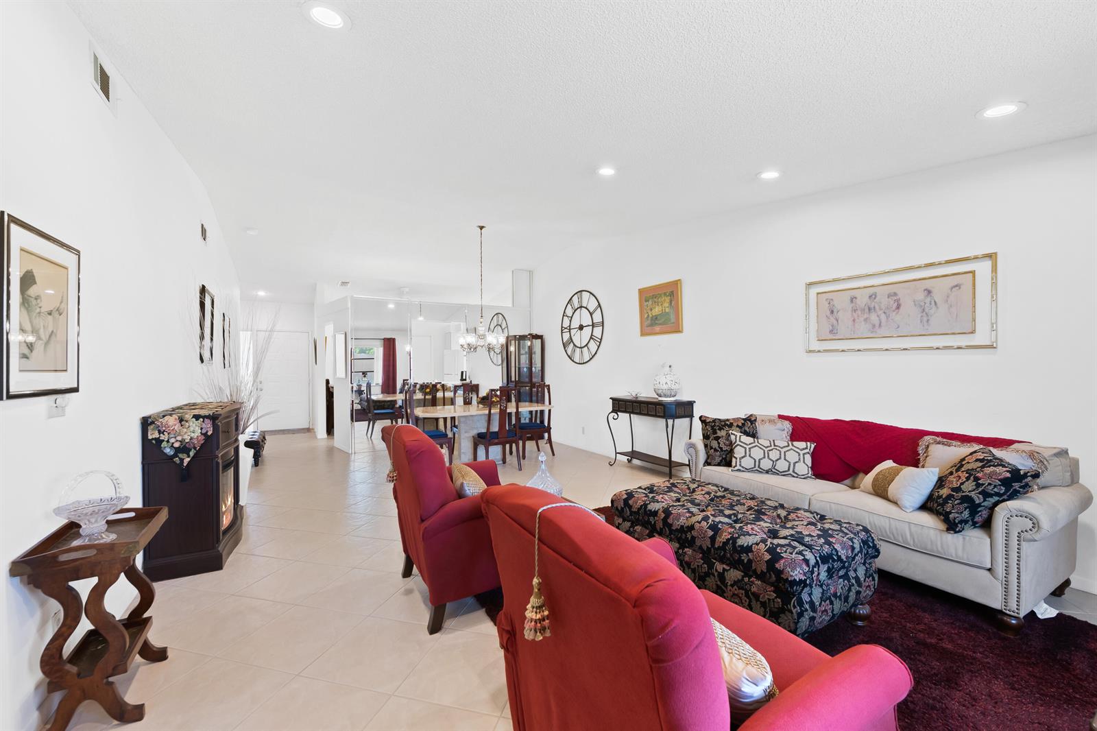 A living room with tile floors, red armchairs, a beige sofa, and a dining area — 8236 Summerbreeze Lane, Boca Raton FL 33496, BOCA RATON, FL