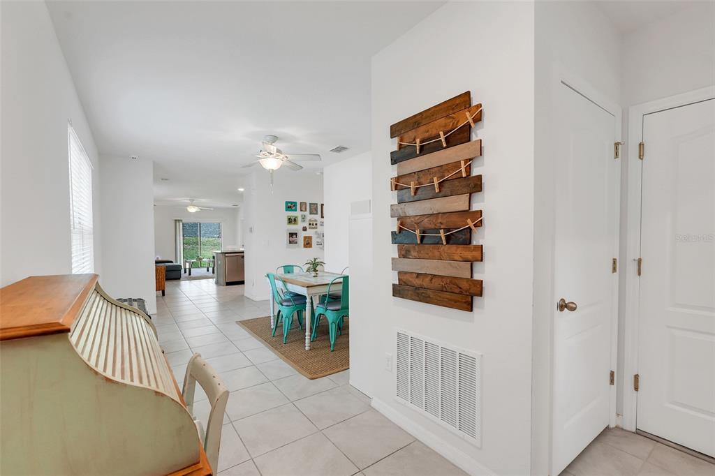 A view of a dining area and hallway featuring tile floors and a wooden wall display — 2782 TIMBER HAWK CIRCLE, OCOEE, FL