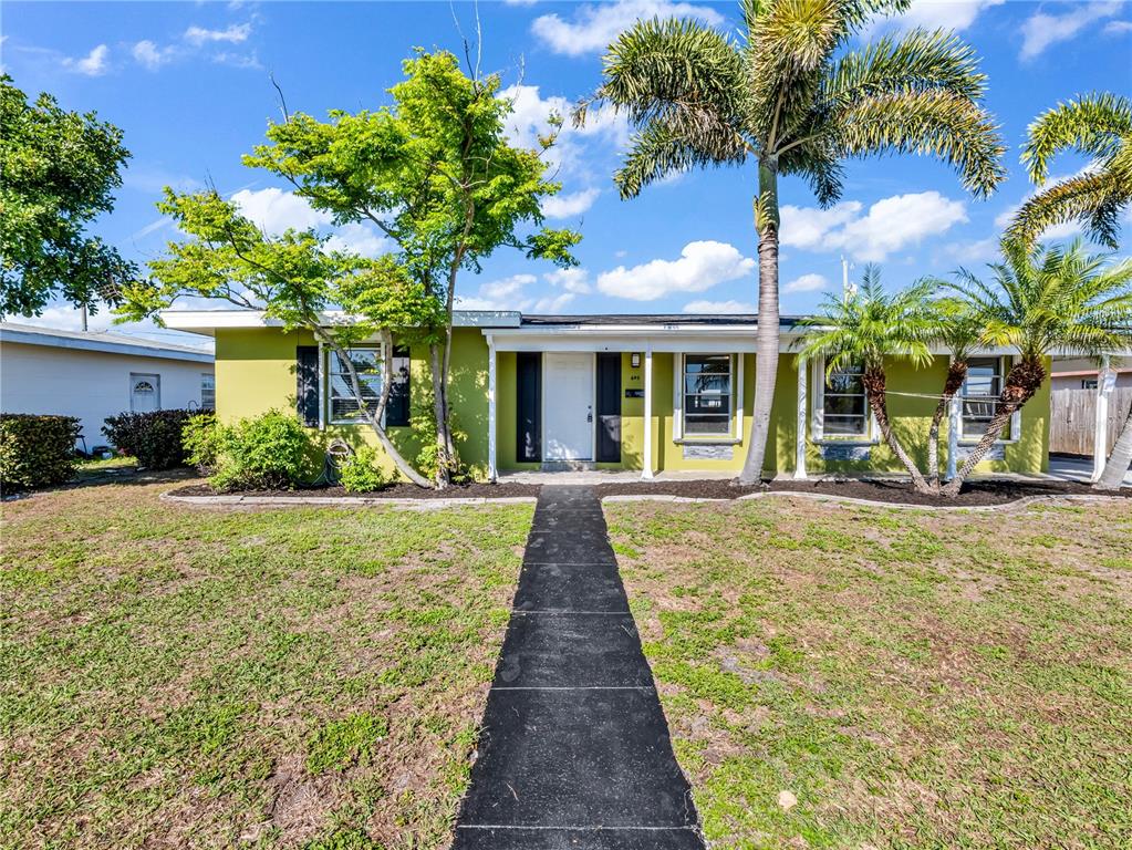A single-story house with a lime green exterior, a front walkway, and palm trees — 640 DALTON BOULEVARD, PORT CHARLOTTE, FL