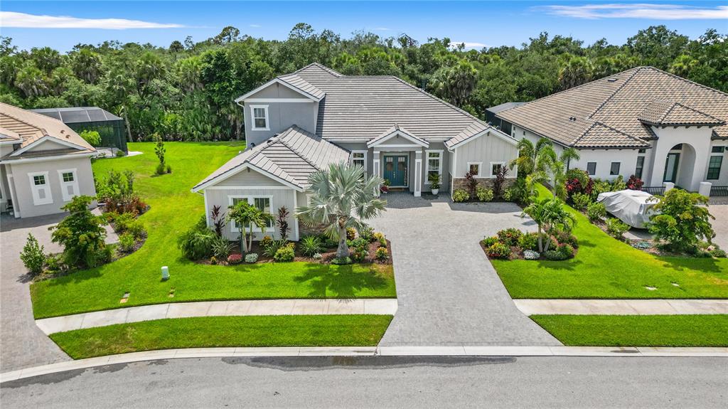 An aerial view of a gray suburban house with a paved driveway and landscaped lawn — 9479 TEQUILA SUNRISE DRIVE, SARASOTA, FL