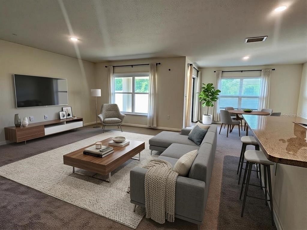 A living room features a grey sectional sofa, a wooden coffee table, and a television — 8696 SW 49TH CIRCLE, OCALA, FL