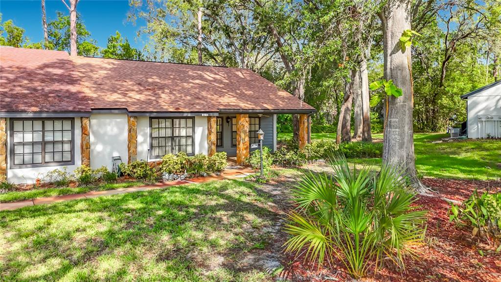 A single-story house with a shingled roof, stone pillars, and a front walkway — 2077 WOODCUTTER COURT, SPRING HILL, FL