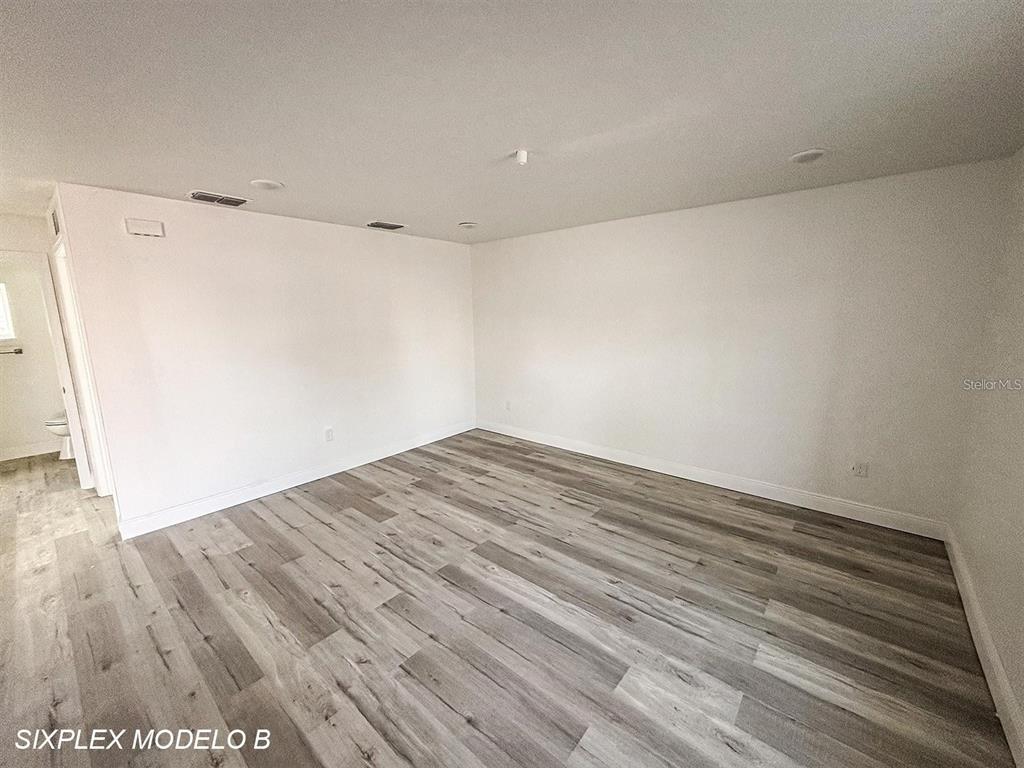 An empty room features white walls, recessed lighting, and light-colored wood-look flooring — 2201 CONWAY DRIVE UNIT 101, DELTONA, FL