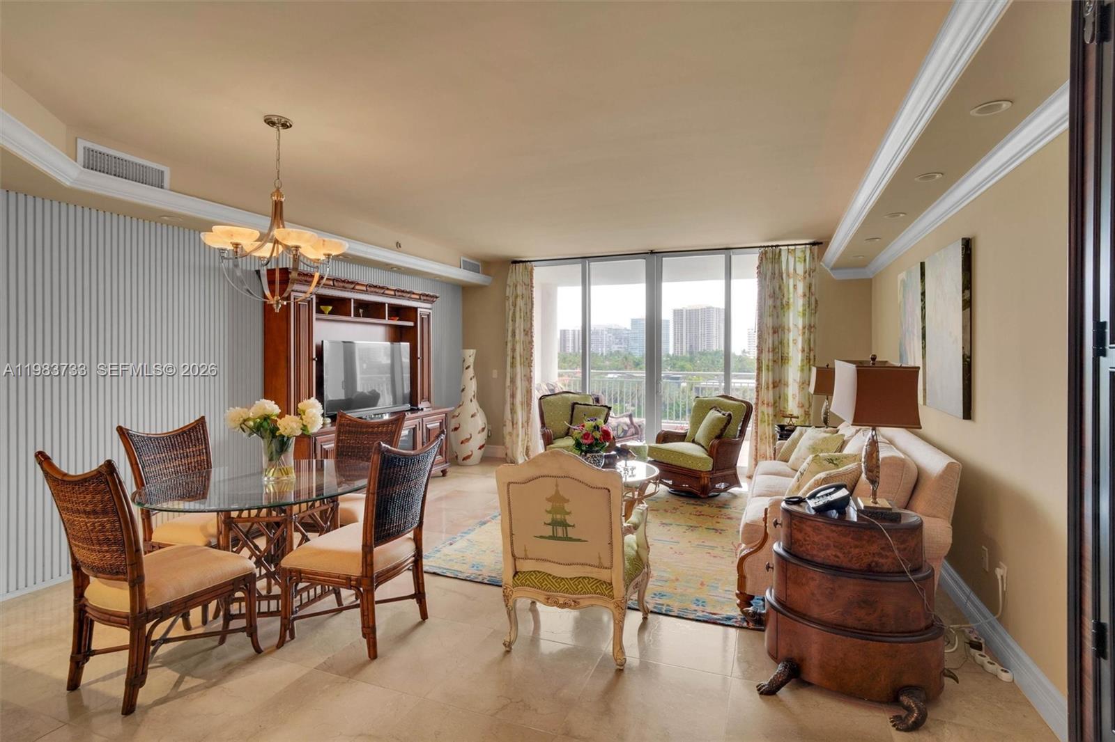 A living and dining area features a glass-top table, wicker chairs, and a balcony view — 9751 E Bay Harbor Dr # 6C, Bay Harbor Islands FL 33154, BAY HARBOR ISLANDS, FL