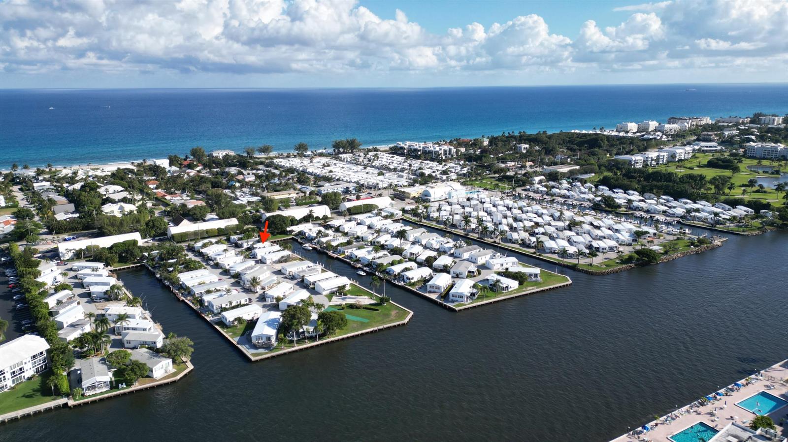 An aerial view shows a waterfront mobile home community with a red arrow pointing down — 203 S Ibis Drive # R, Briny Breezes FL 33435, BRINY BREEZES, FL