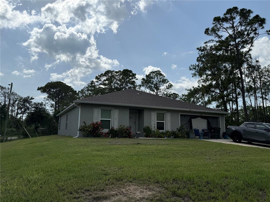 A single-story house with a gray exterior, a shingled roof, and an attached garage — 7578 TASCO DRIVE, NORTH PORT, FL