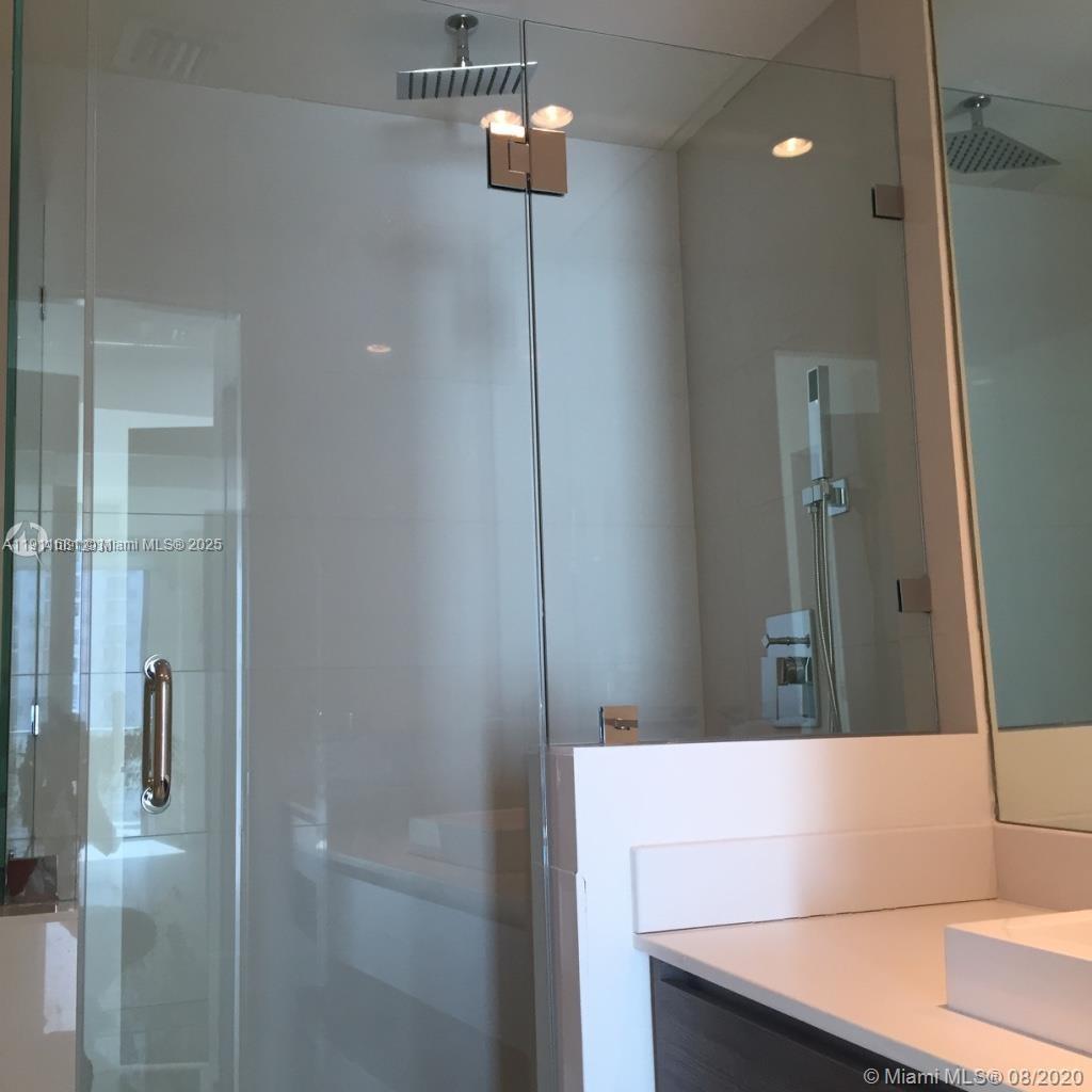 A modern bathroom features a glass-enclosed shower with a rainfall showerhead and a vanity — 1100 S Miami Ave # 2911, Miami FL 33130, MIAMI, FL