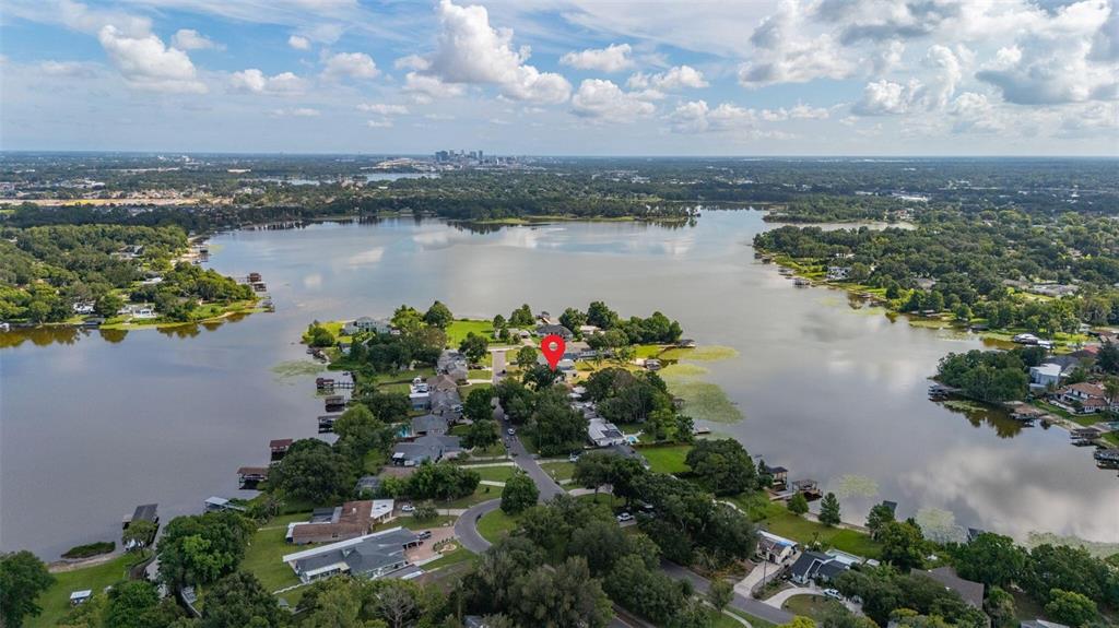 An aerial view shows a residential neighborhood on a peninsula surrounded by a large lake — 5701 PADGETT CIRCLE, ORLANDO, FL