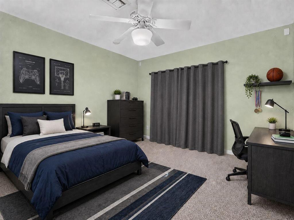 A bedroom features a bed with blue bedding, a desk, a dresser, and gray curtains — 5701 PADGETT CIRCLE, ORLANDO, FL