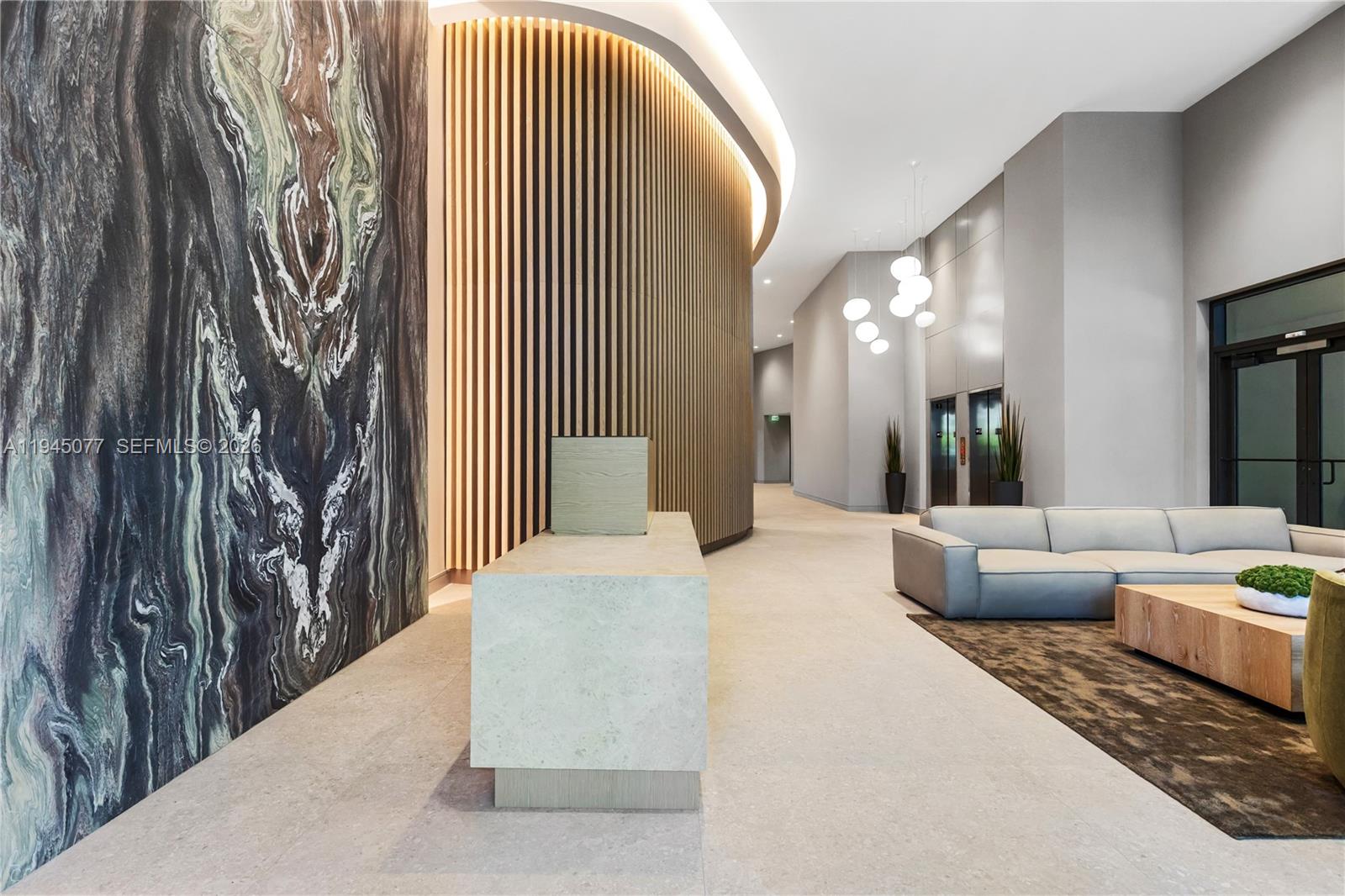 A modern lobby features a stone reception desk, a curved wood-slat wall, and a seating area — 3034 Oak Avenue, Coconut Grove FL 33133, COCONUT GROVE, FL