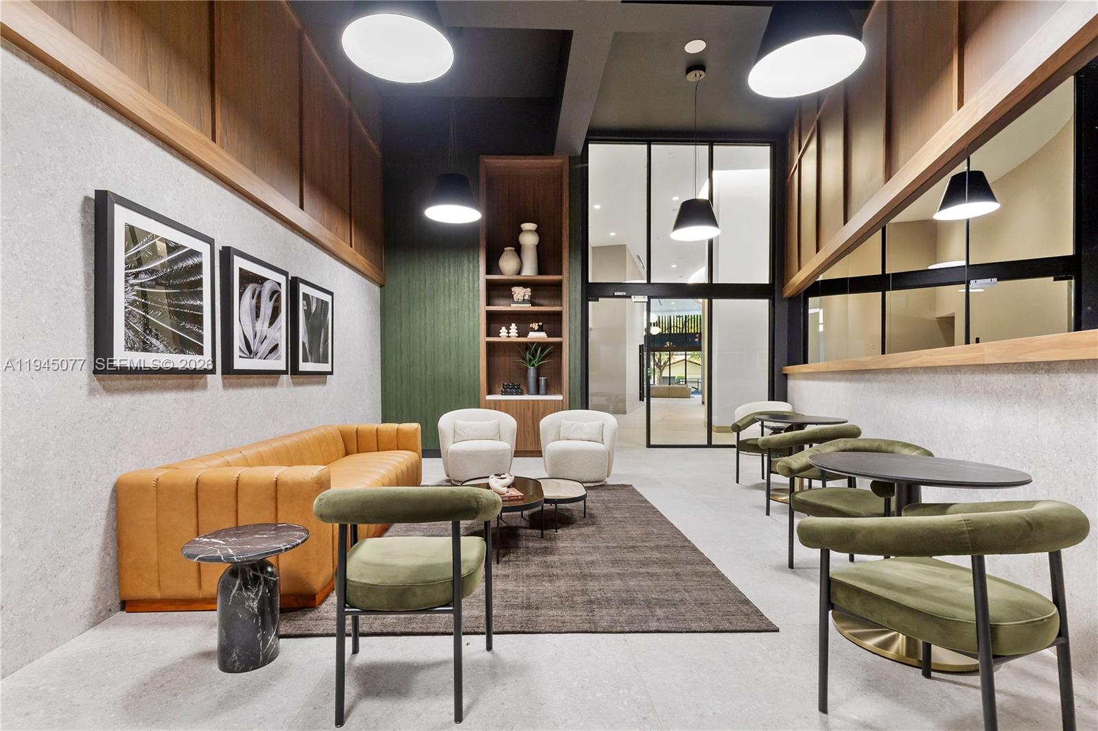 A modern lounge area features a tan sofa, green velvet chairs, and wood-paneled walls — 3034 Oak Avenue, Coconut Grove FL 33133, COCONUT GROVE, FL