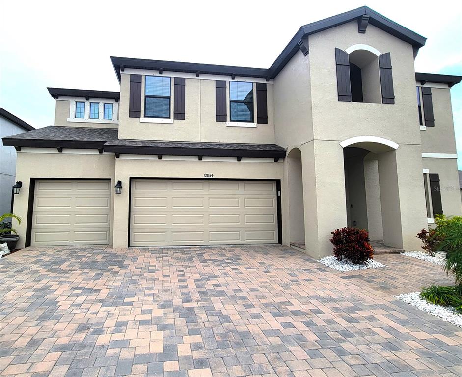 A two-story house with a three-car garage and a paved driveway — 12854 BOGGY CREEK DRIVE, RIVERVIEW, FL