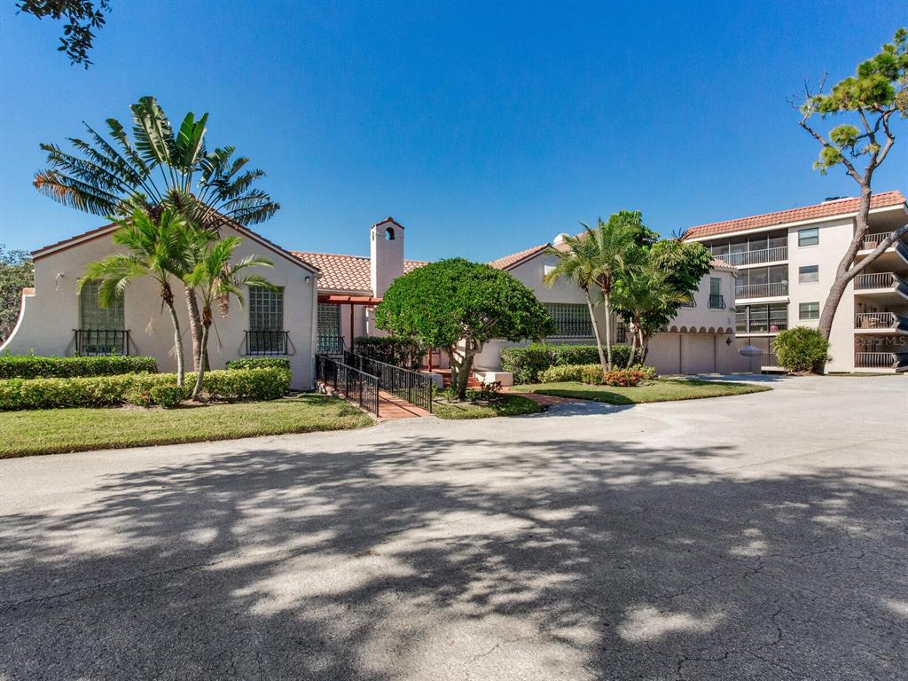 A single-story building with a tile roof, palm trees, and a paved driveway — 502 S FLORIDA AVENUE UNIT 124, TARPON SPRINGS, FL
