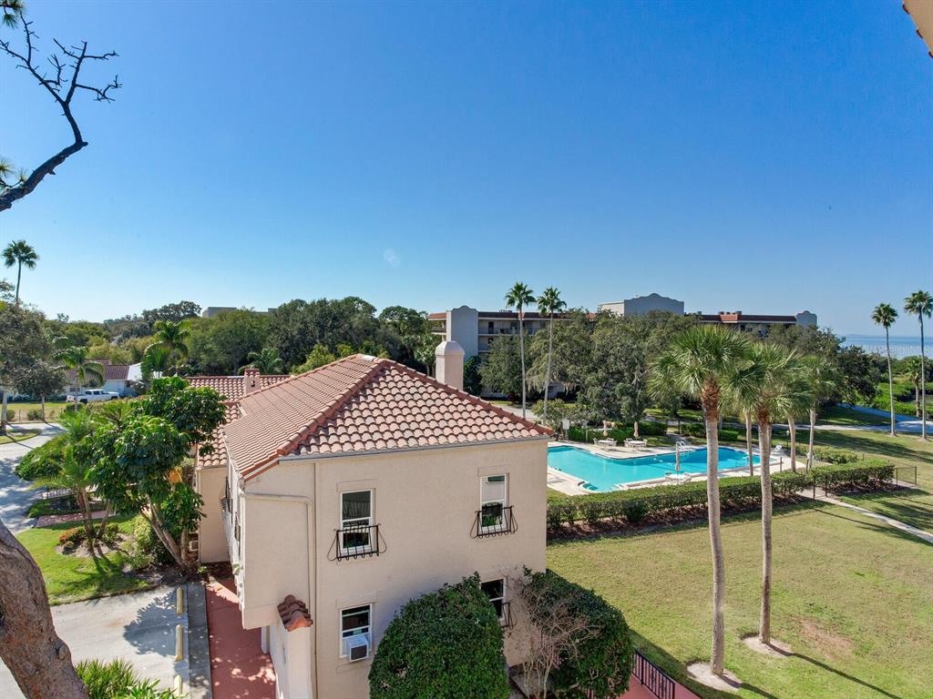 An elevated view shows a tan building with a tiled roof next to a swimming pool — 502 S FLORIDA AVENUE UNIT 124, TARPON SPRINGS, FL