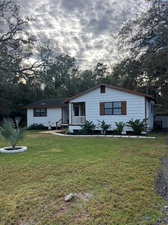 A single-story white house with brown shutters and a small front porch sits on grass — 512 STALLINGS AVENUE, DELTONA, FL