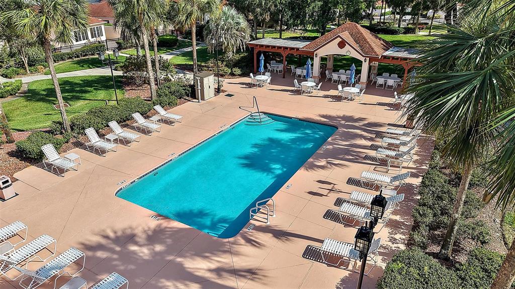 An aerial view shows a rectangular swimming pool surrounded by lounge chairs and a pavilion — 716 DOMINGUEZ DRIVE, LADY LAKE, FL