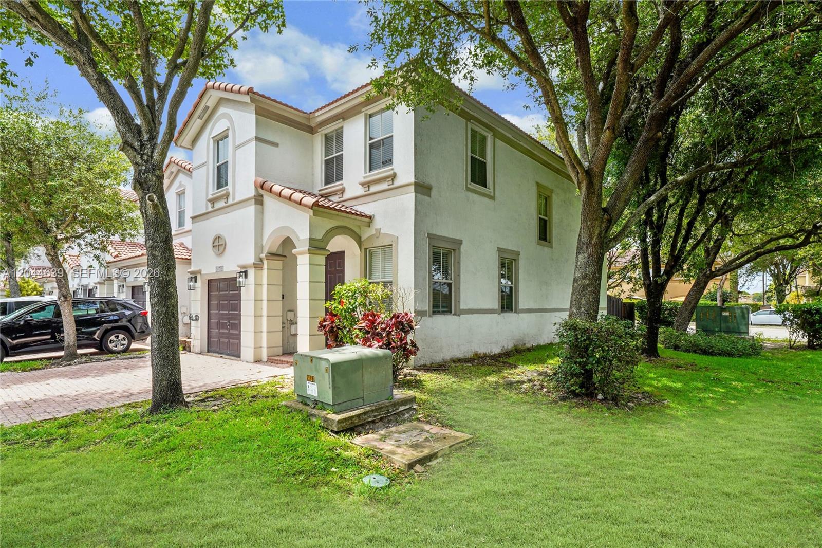A two-story stucco house with a tile roof, a garage, and a green utility box — 10709 NW 81st Ln, Doral FL 33178, DORAL, FL