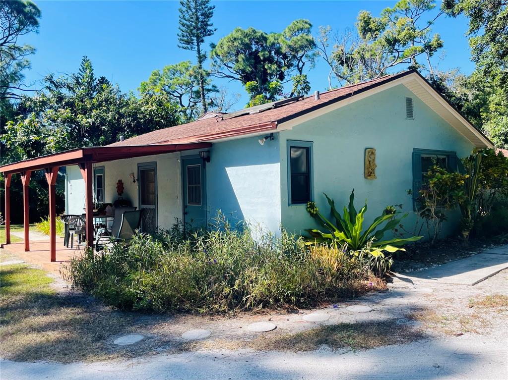A light blue, single-story house with a covered porch and a brown shingled roof — 550 46TH STREET, SARASOTA, FL