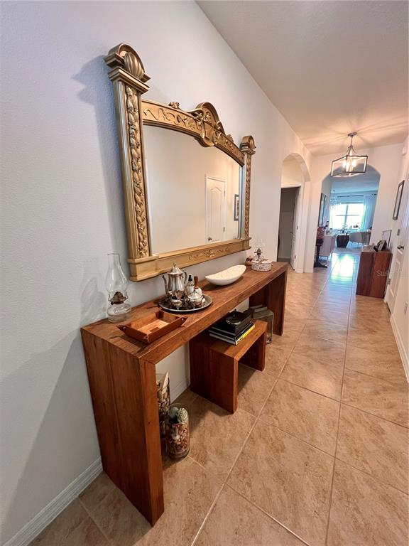 A hallway features a wooden console table with a large ornate gold mirror above it — 1267 IGUANA LOOP, DAVENPORT, FL