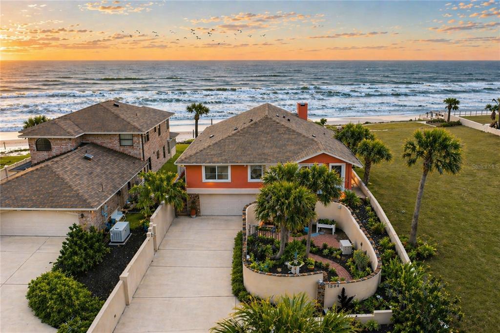 An aerial view shows two coastal houses with driveways and landscaping facing the ocean — 1504 N ATLANTIC AVENUE, DAYTONA BEACH, FL