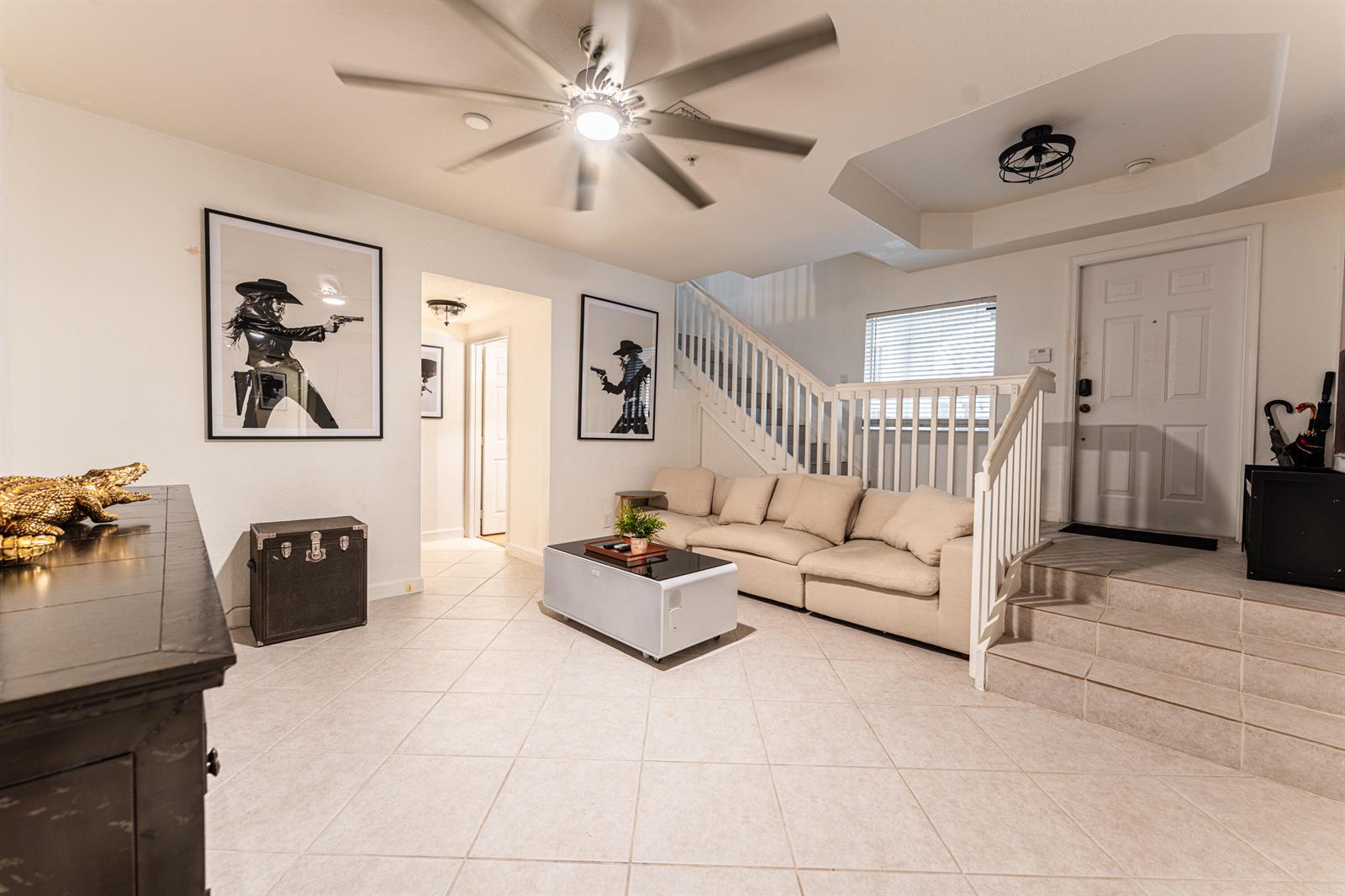 A living room features a beige sectional sofa, tile flooring, a ceiling fan, and wall art — 1208 Coastal Bay Boulevard, Boynton Beach FL 33435, BOYNTON BEACH, FL