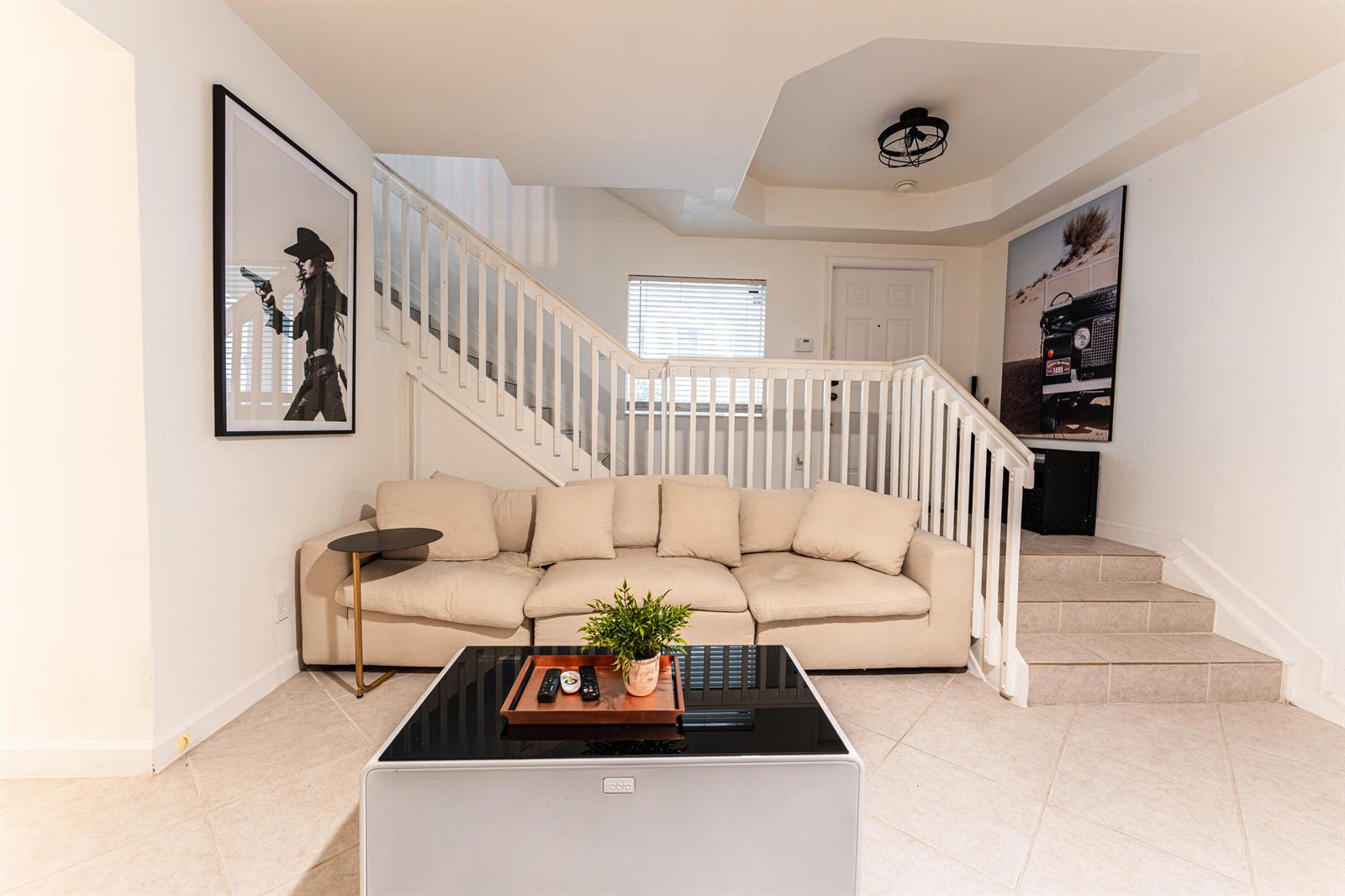 A living room features a beige sofa, a glass-topped coffee table, and stairs with railings — 1208 Coastal Bay Boulevard, Boynton Beach FL 33435, BOYNTON BEACH, FL