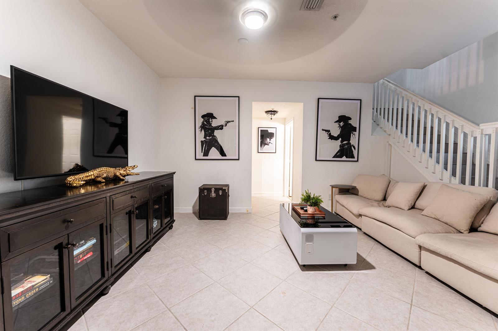 A living room features a large television, a black media console, and a beige sofa — 1208 Coastal Bay Boulevard, Boynton Beach FL 33435, BOYNTON BEACH, FL