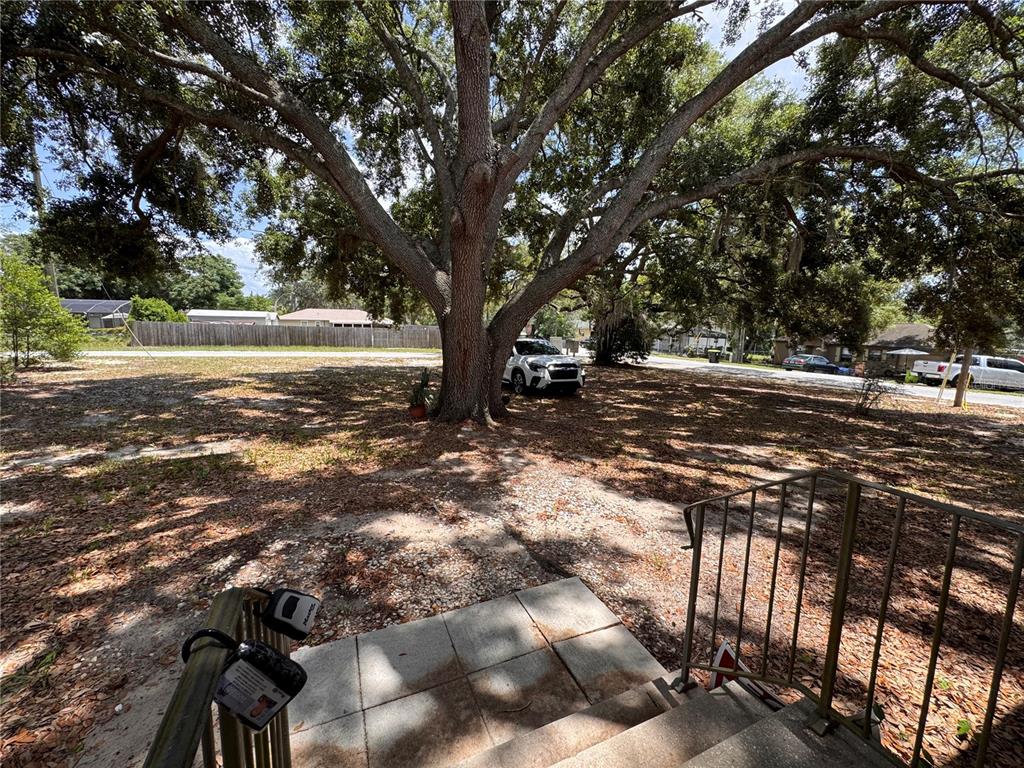A two-story house with light siding stands behind a large tree in a yard — 538 ORANGE STREET UNIT 538, MASCOTTE, FL