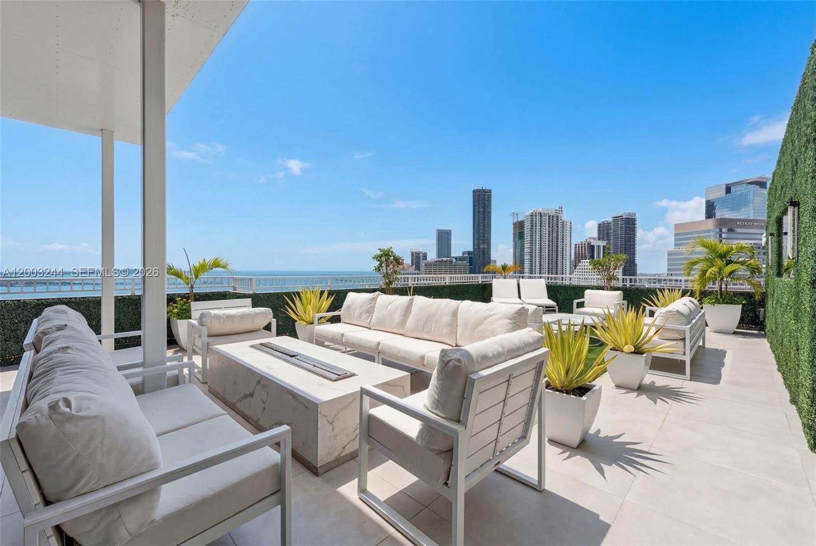 A modern rooftop terrace features white outdoor furniture, a marble fire pit, and city views — 801 Brickell Key Blvd, Miami FL 33131, MIAMI, FL