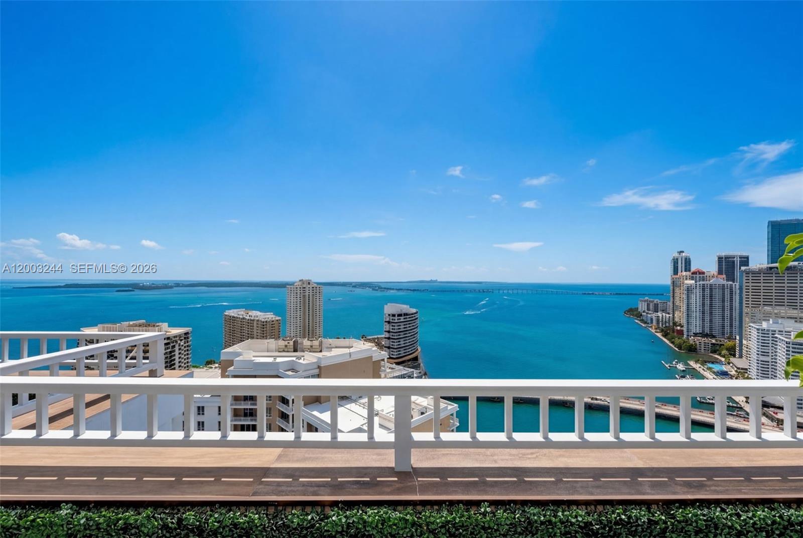 A balcony with a white railing overlooks a bay with high-rise buildings and water — 801 Brickell Key Blvd, Miami FL 33131, MIAMI, FL