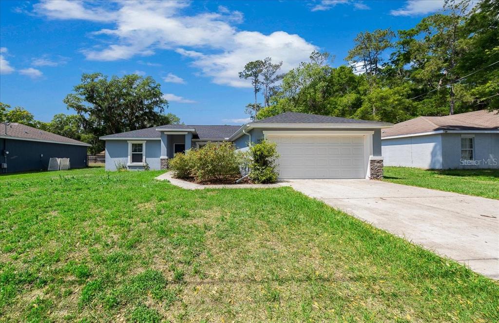 A single-story house with a blue exterior, a two-car garage, and a concrete driveway — 5488 NW 61ST AVENUE, OCALA, FL