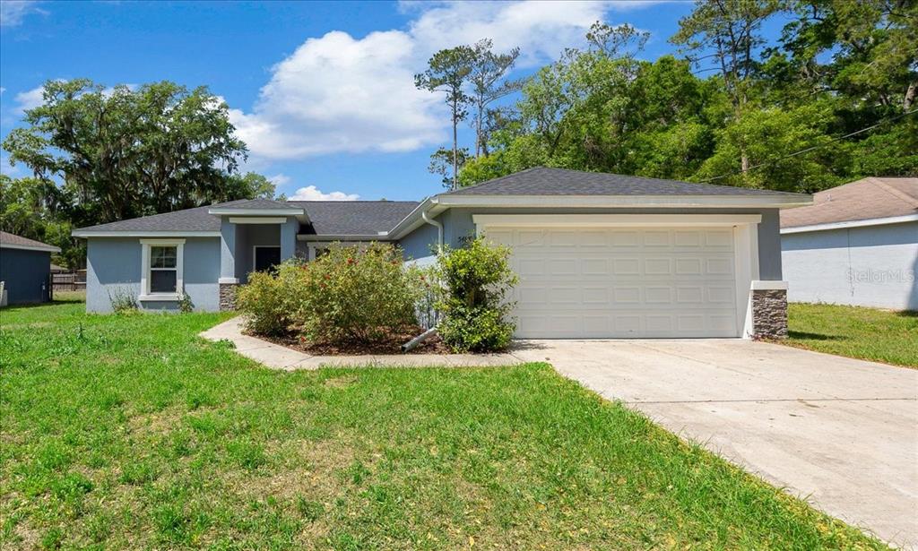 A single-story house with a gray exterior, a two-car garage, and a front lawn — 5488 NW 61ST AVENUE, OCALA, FL