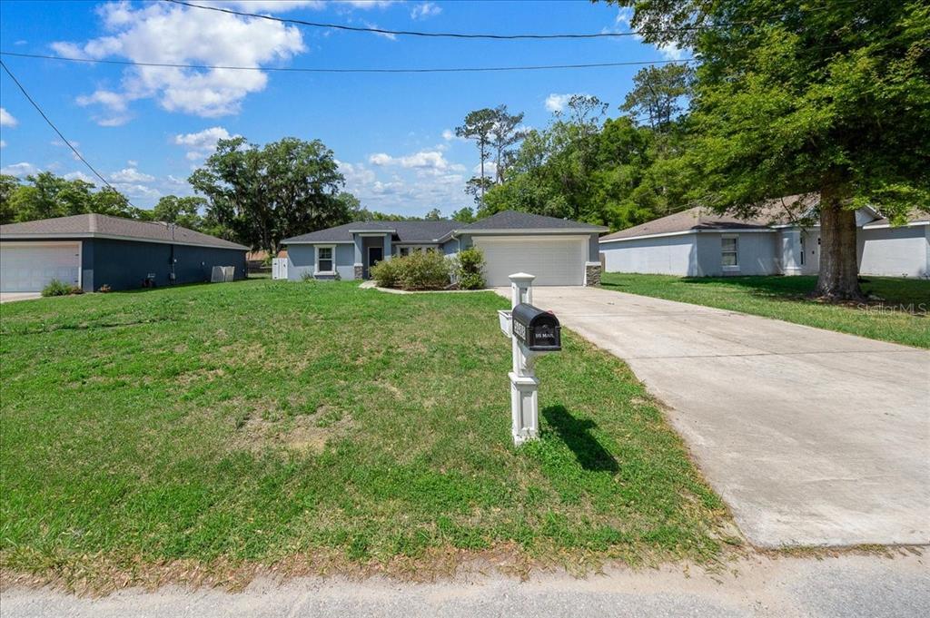 A single-story house with a gray exterior, a two-car garage, and a concrete driveway — 5488 NW 61ST AVENUE, OCALA, FL