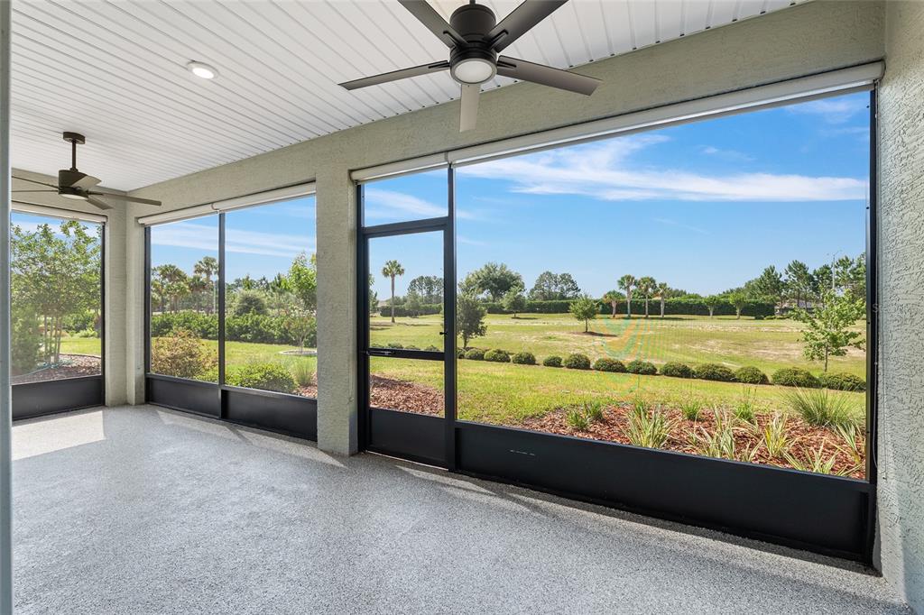 A screened-in patio with a concrete floor, ceiling fans, and a view of a grassy yard — 8837 SW 79TH LOOP, OCALA, FL