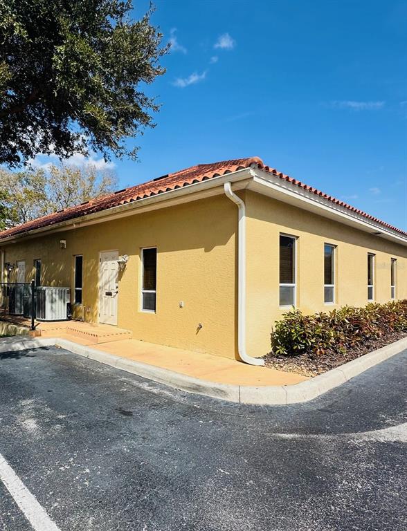 The exterior of a yellow, single-story commercial building with a tiled roof and parking lot — 5115 S LAKELAND DRIVE, LAKELAND, FL
