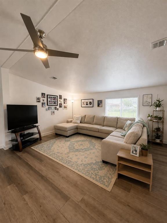 A living room features a sectional sofa, a television on a stand, and wood-look flooring — 3627 TOM MATTHEWS ROAD, LAKELAND, FL