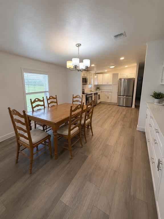 A dining area with a wooden table and chairs sits adjacent to a modern kitchen — 3627 TOM MATTHEWS ROAD, LAKELAND, FL