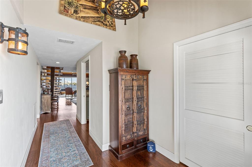 An entryway features a wooden cabinet, a runner rug, and a view into a living area — 761 MARINA POINT DRIVE UNIT 7610, DAYTONA BEACH, FL