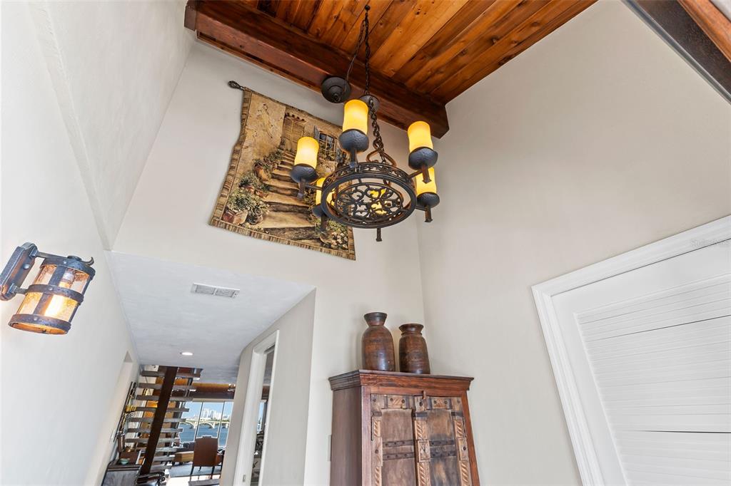 An entryway features a wood-paneled ceiling, a decorative chandelier, and a tapestry on the wall — 761 MARINA POINT DRIVE UNIT 7610, DAYTONA BEACH, FL