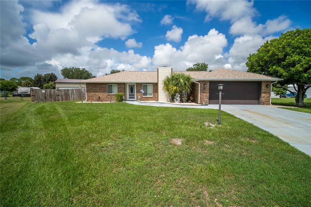 A single-story brick house with a brown garage door and a large front lawn — 751 VEGA COURT NE, PALM BAY, FL