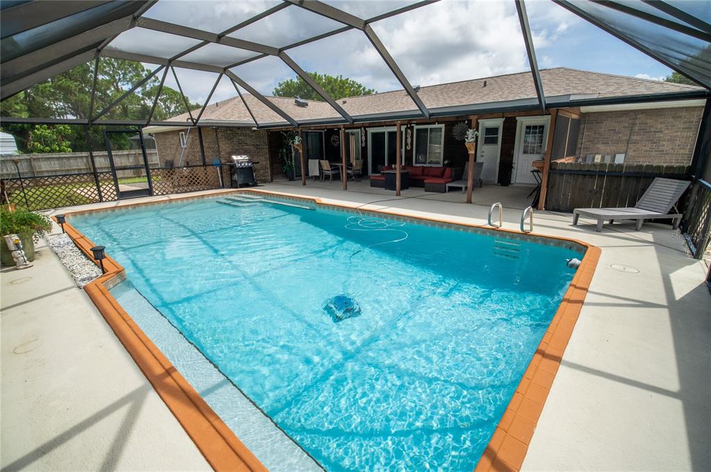 A screened-in swimming pool with a brick patio and a covered outdoor seating area — 751 VEGA COURT NE, PALM BAY, FL
