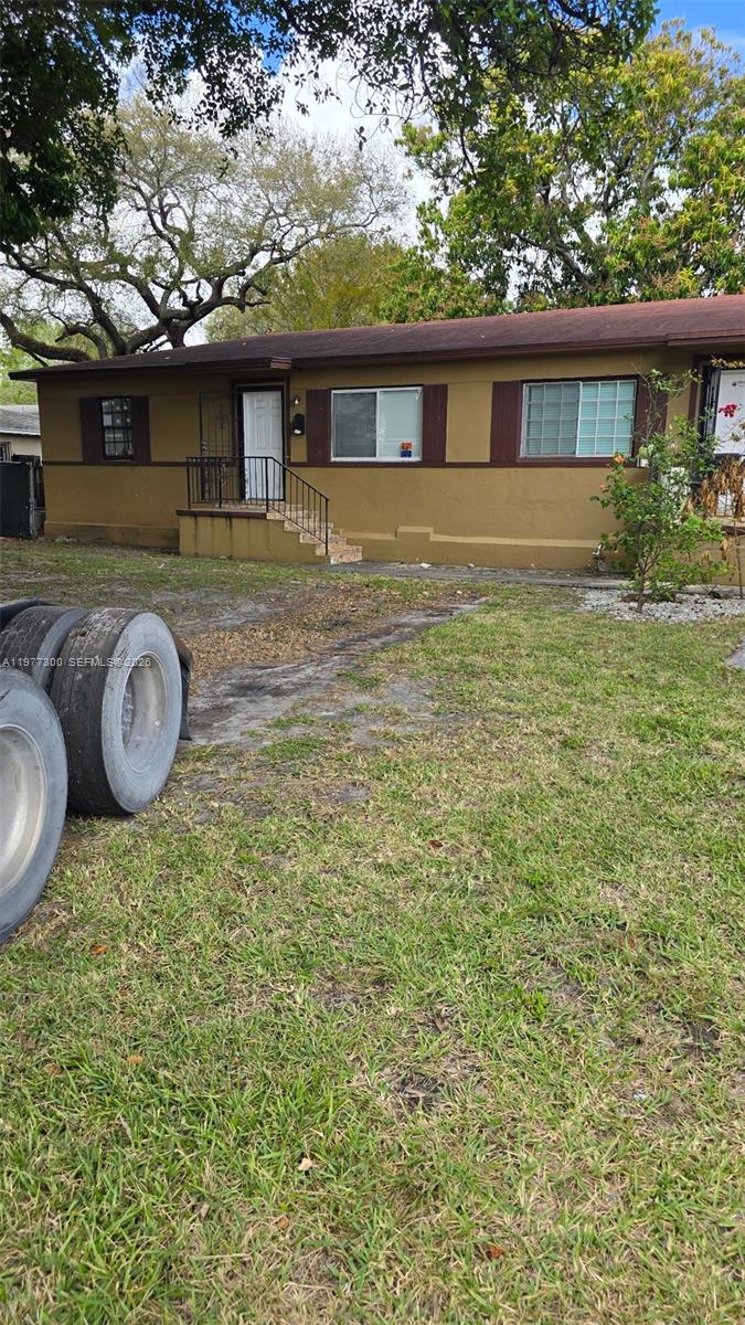 A single-story house with brown exterior walls, a dark roof, and a front porch — 6910 NW 5th Pl, Miami FL 33150, MIAMI, FL