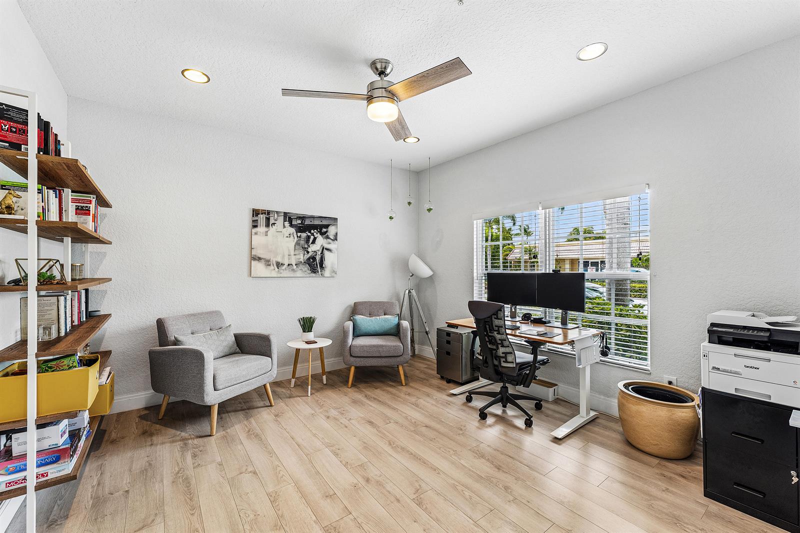 A home office features a desk, two armchairs, a bookshelf, and light wood flooring — 295 NE 5th Avenue # 22, Delray Beach FL 33483, DELRAY BEACH, FL