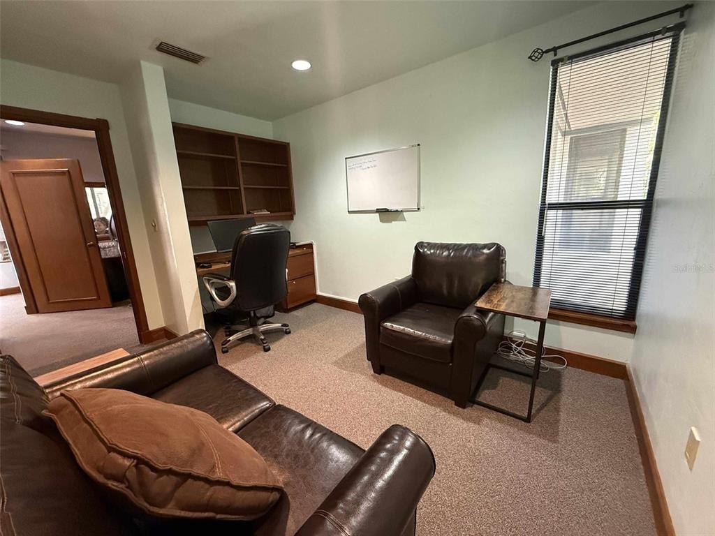 A home office features a desk, leather seating, a whiteboard, and a window with blinds — 2833 NW 41ST STREET UNIT 140 Room B, GAINESVILLE, FL